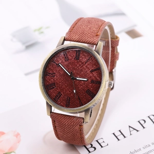 Close-up of vintage bronze watch with Roman numerals on brown textured dial and leather strap