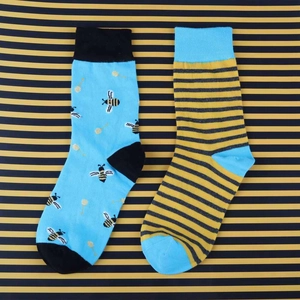 Close-up of cotton crew socks featuring bee patterns and stripes in blue and yellow