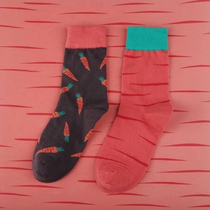 Detail shot of two cotton crew socks featuring orange carrot patterns and red stripes