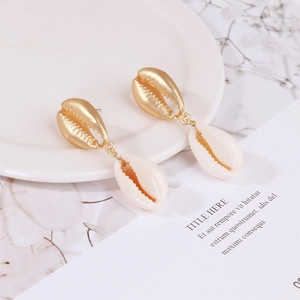 Detail view of Bohemian seashell earrings with gold conch stud and natural white shell
