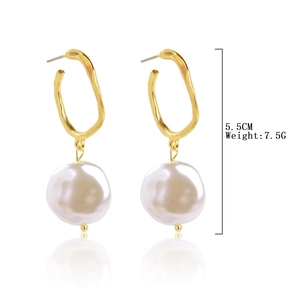 Detailed view of bohemian gold irregular hoop earrings with large baroque pearls