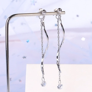Elegant silver S-shaped wave tassel earrings with zircons shown on a star-blue background