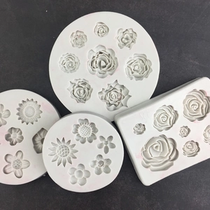 Vue détaillée de quatre moules en silicone blanc avec textures de roses et tournesols