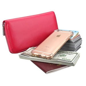 Macro view of rose pink leather passport wallet holding iPhone, cash and credit cards