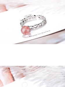 Macro shot of silver heart ring with pink strawberry quartz on a decorative card