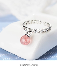 Detailed view of strawberry quartz bead on a silver open ring with heart patterns