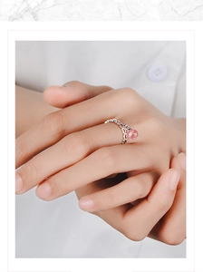 Close-up of a pink strawberry quartz ring with silver hollowed-out metal design