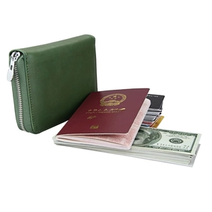 Detail view of dark green leather RFID travel wallet holding a passport, cards, and cash