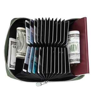 Macro view of green canvas accordion card holder wallet showing passport and cash storage
