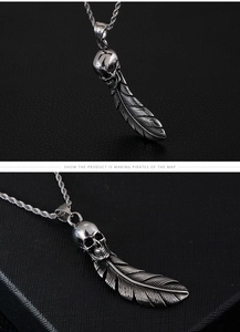 Macro detail of silver stainless steel skull and feather pendant with twisted chain