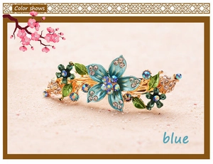 Macro shot of vintage blue floral hair barrette with gold metal base and rhinestones