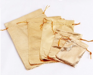 Detailed set of five gold drawstring gift pouches in various sizes on white background