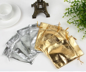 Detailed view of shimmering gold and silver drawstring gift bags with woven texture