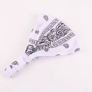 Detail of white paisley cotton headband showing elastic pleated design and soft texture