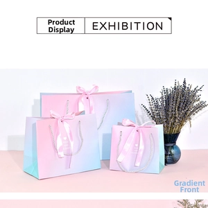 Detail of gradient gift bags with pink ribbons and Rich and Colourful printed logos