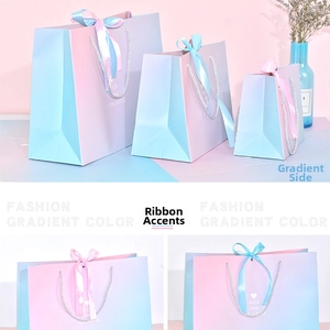 Detail of blue and pink gradient gift bags with silk ribbons and stylish typography