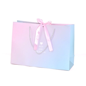 Pink and blue gradient gift paper bag with pink satin bow and heart pattern design