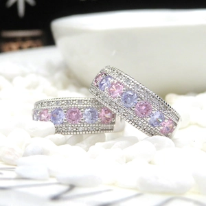 Detailed close-up of silver-tone eternity rings with pink, purple and white zircons
