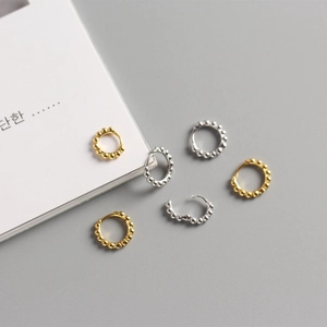 Detailed macro view of S925 sterling silver beaded mini hoop earrings in gold and silver