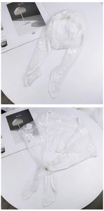 Detailed view of white floral lace embroidery on sheer fabric scarf with wavy edges
