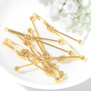 Golden ball head jewelry connector pins for DIY earring making on a white plate