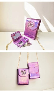 Macro detail of purple laser shoulder bag showing heart charm and metal chain strap