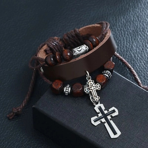 Close-up of multilayer brown leather bracelet with wood beads and silver cross charm