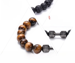 Detailed view of lava stone and tiger eye beads with engraved dumbbell charm