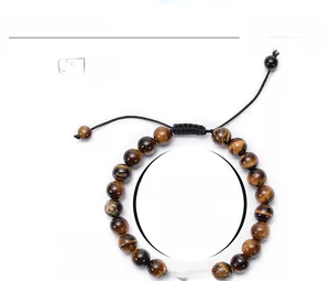 Macro detail of 8mm tiger eye stone beads with silver dumbbell charm and braided cord