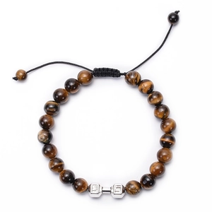 Macro view of woven tiger eye stone bracelet featuring a silver dumbbell fitness charm