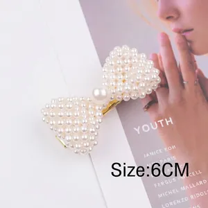 Detail of 6CM white pearl bow hair clip with gold metal duckbill base and intricate beads