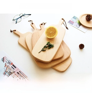 Stacked rectangular beech wood cutting boards with handle and leather lanyard detail