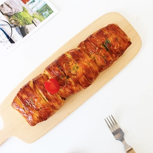 Japanese beech wood cutting board with pastry, tomato garnish on a white background