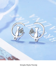 Close-up of cat and crescent moon stud earrings with sparkling cubic zirconia stones
