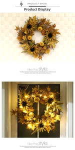 Detail of autumn wreath with sunflowers, pumpkins and LED lights on a white wall