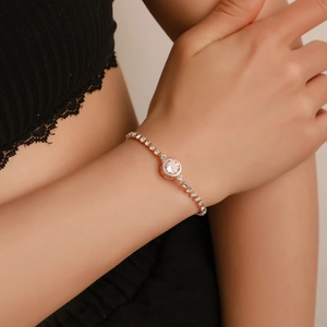Detail of rose gold tennis bracelet with central round zircon on woman's wrist