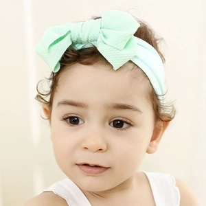 Close-up of mint green waffle texture bow on a soft nylon headband for baby girls