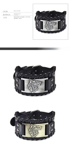 Close-up of punk leather bracelet showing wolf head metal relief and braided cord edges