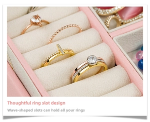 Close-up of pink leather jewelry box featuring ring slots with several elegant rings