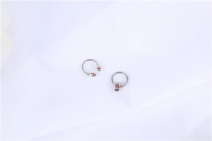 Macro detail of gothic skull piercing rings in surgical steel with red rhinestone eyes