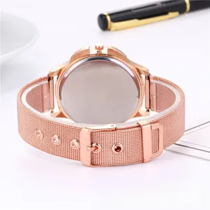Détail du bracelet de montre en maille or rose et du boîtier en métal poli à l'arrière