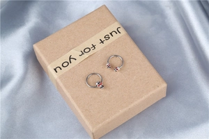 Macro detail of steel horseshoe ring and captive bead ring with red-eyed skull charms