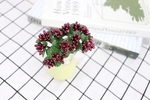Close-up of deep red artificial berries in a ceramic vase for home and wedding decor