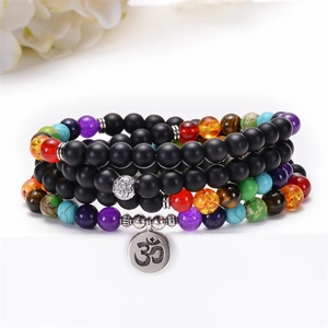 Détail de perles de chakra noir mat avec pendentif Om argenté sur bracelet de yoga
