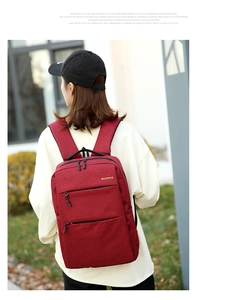 Burgundy water-resistant oxford backpack with USB charging port shown in outdoor setting