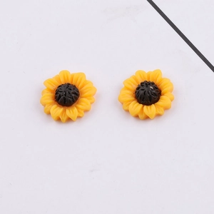Detail view of yellow resin sunflower charms for DIY jewelry and hair accessories