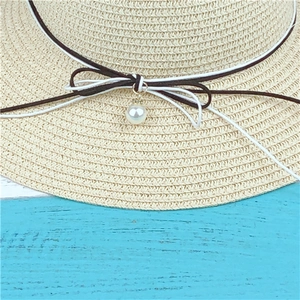 Beige woven straw sun hat featuring double-tone bow knot and elegant pearl charm detail