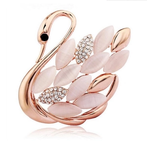 Detail of rose gold swan brooch featuring pink cat-eye stones and sparkling crystals