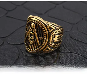 Macro shot of gold Masonic ring with Square and Compass symbol on black leather background