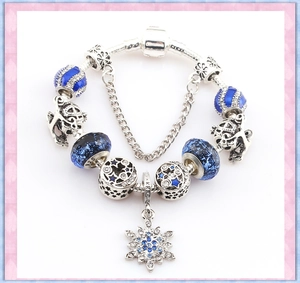 Detail of silver S925 beaded bracelet with blue glass beads and snowflake charm